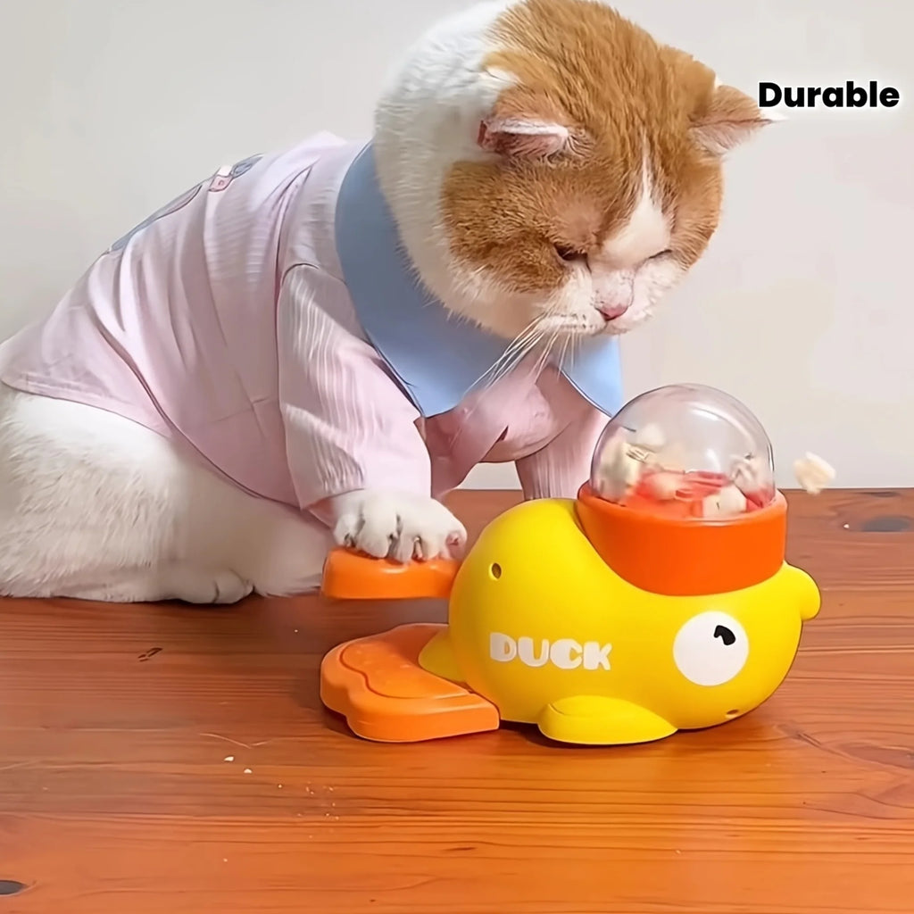 A cat pressing the paddle to release treats into the clear dome